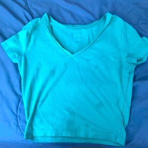 cropped mint V-neck shirt.